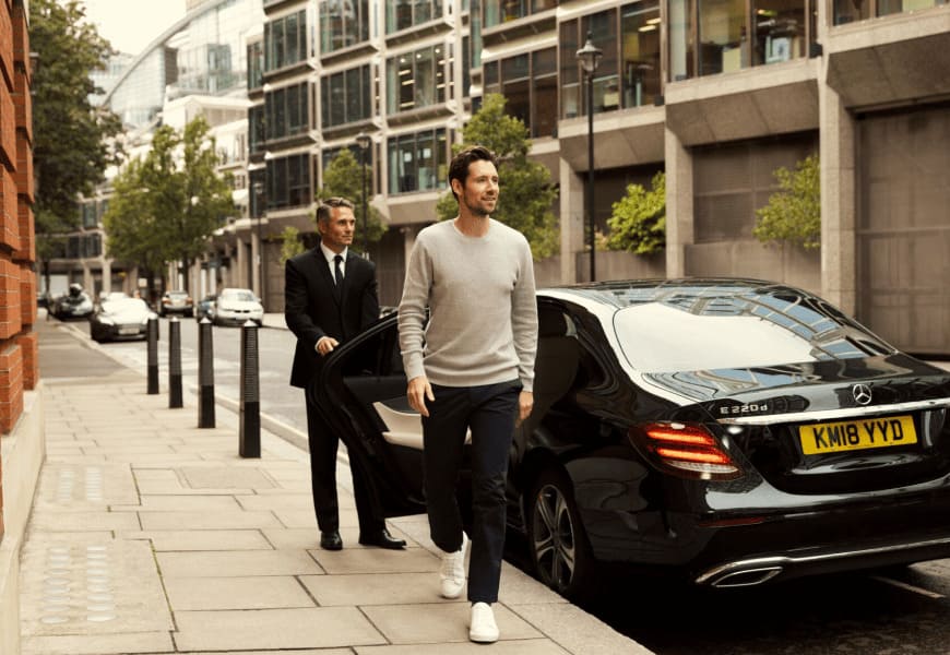The customer's gate is being opened by a chauffeur. The client is gracefully exiting the gate of a Mercedes S-Class.